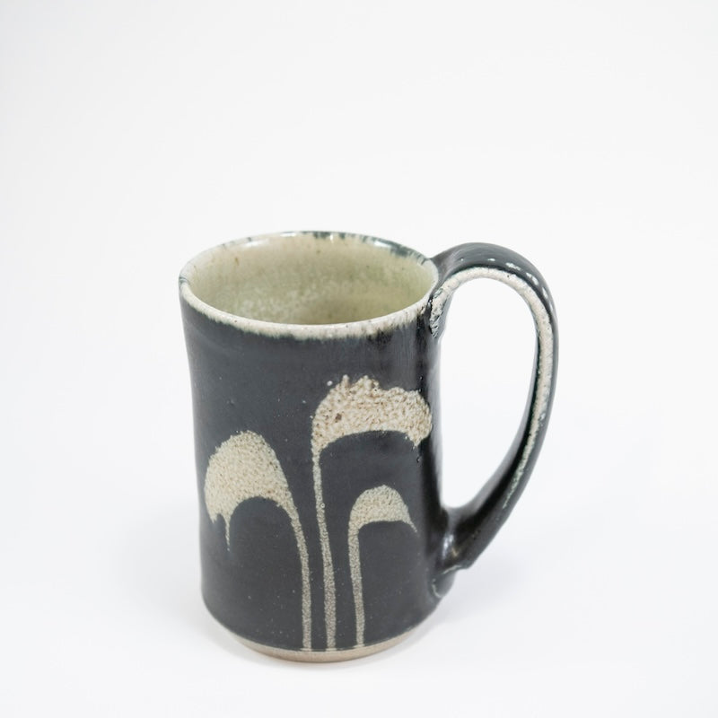 Taza alta en color negro con hierba