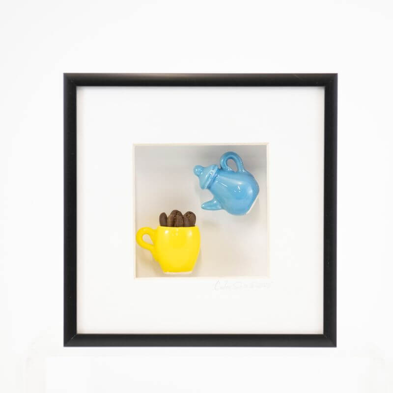 6x6 Shadowbox with a Blue Teapot Pouring into a Yellow Mug of Coffee Beans in a Black Frame