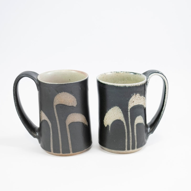 Taza alta en color negro con hierba