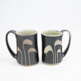 Taza alta en color negro con hierba