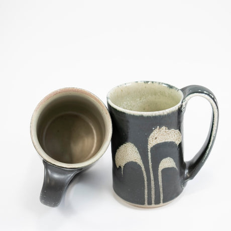 Taza alta en color negro con hierba
