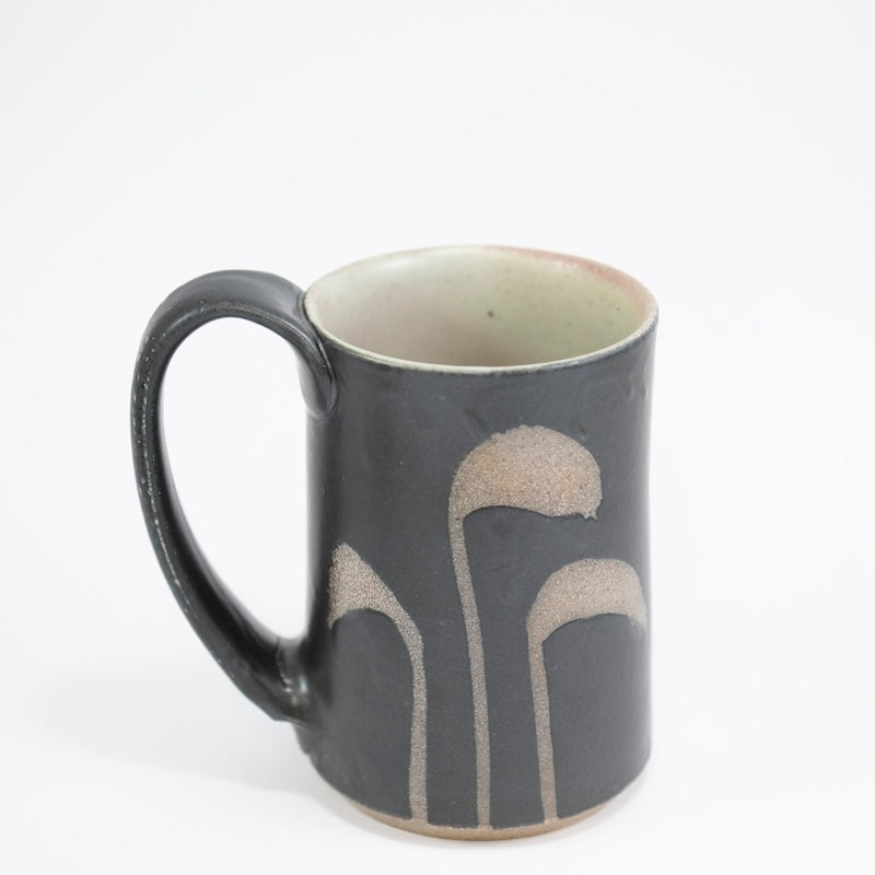 Taza alta en color negro con hierba