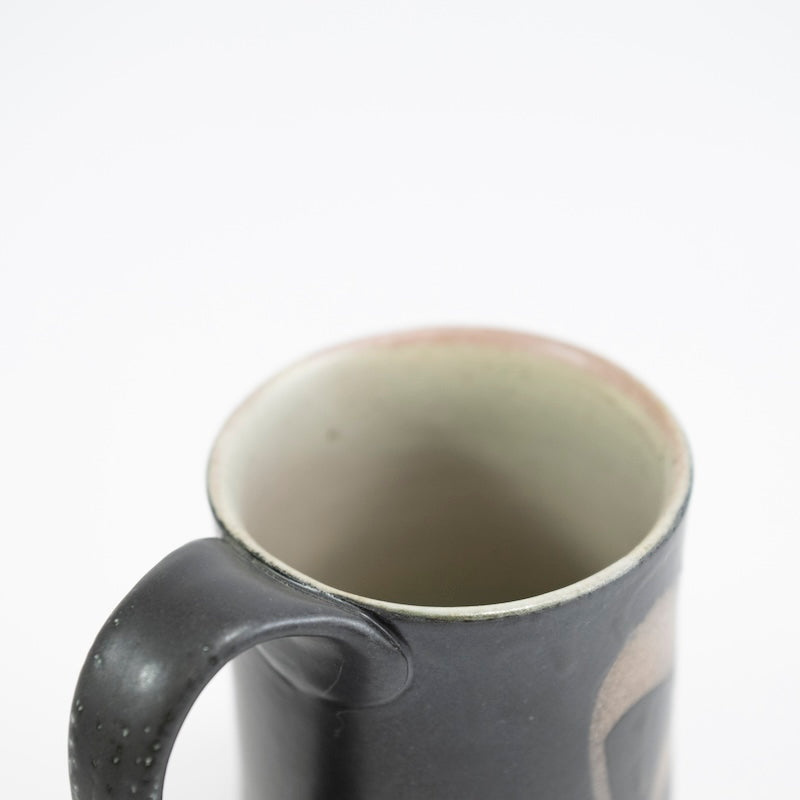 Taza alta en color negro con hierba