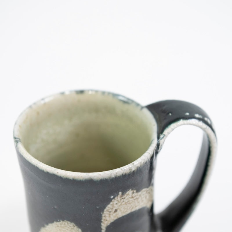 Taza alta en color negro con hierba