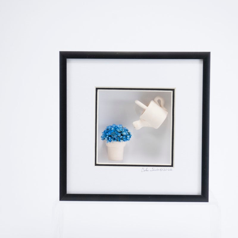 6x6 Shadowbox with a White Watering Can and Blue Flowers in a Black Frame