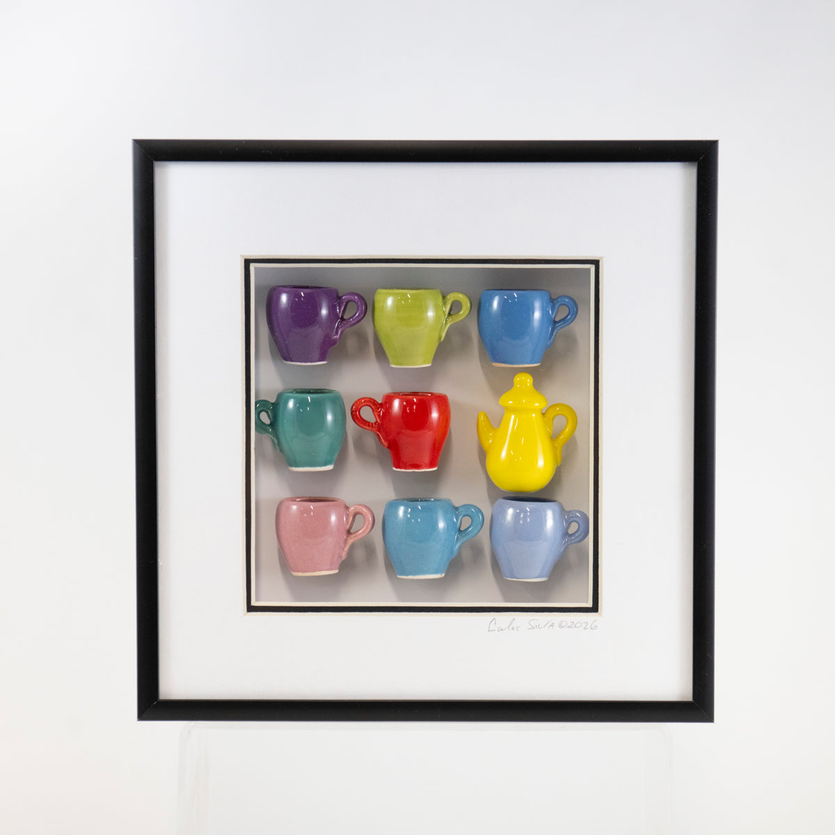 8x8 Shadowbox With a Yellow Teapot and Purple, Red, and Periwinkle Mugs in a Black Frame