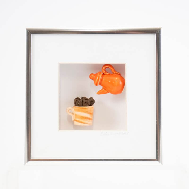 6x6 Shadowbox with an Orange Teapot Pouring into a Cream Coffee Mug in a Silver Frame